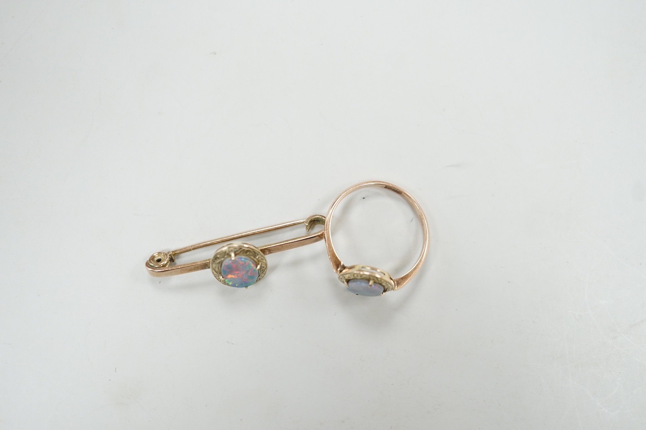 A 9ct and black opal doublet set bar brooch, 38mm and a matching ring, size R, gross weight 5.9 grams.